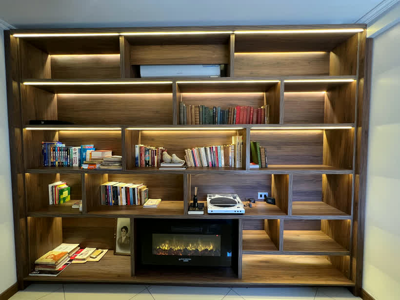 Biblioteca de madera con hogar y luz