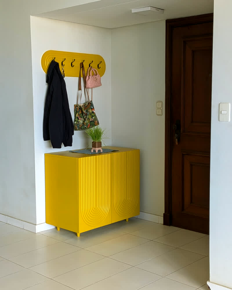 Recibidor de entrada amarillo con percheros